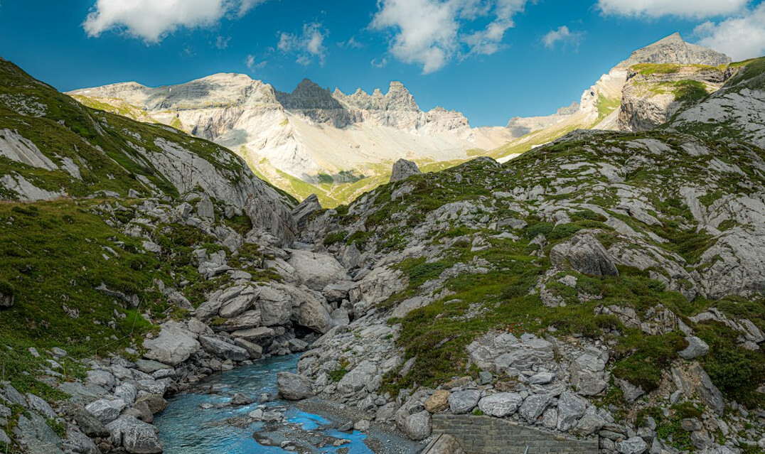Aerial view of a river flowing through a green Swiss alpine valley